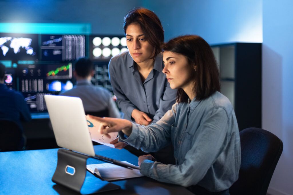 Two women look over computer screen in an office