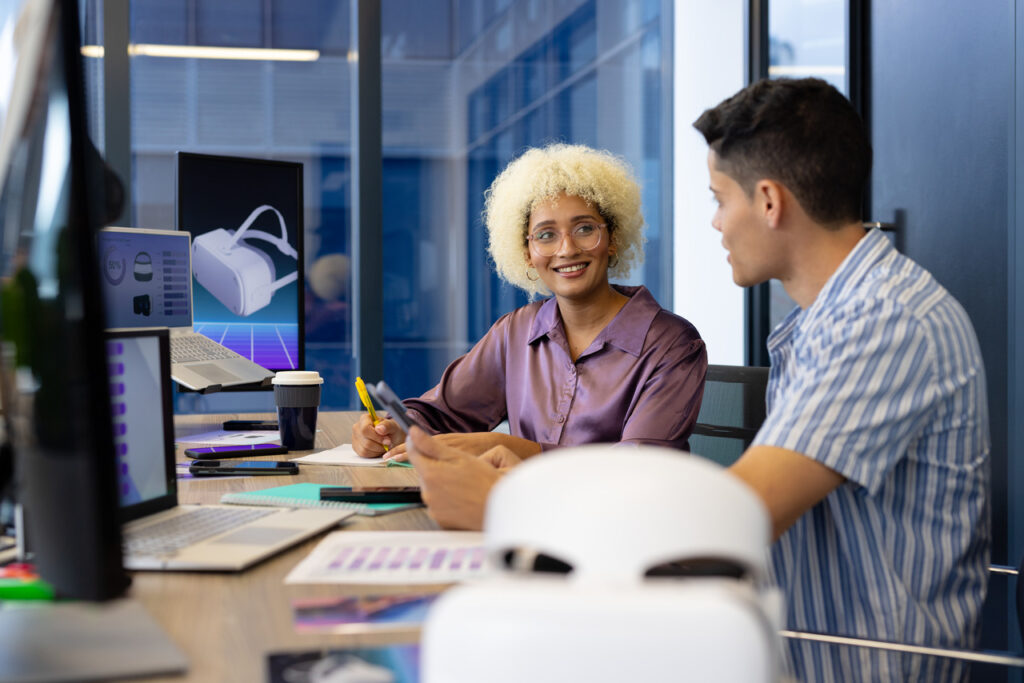 Two young people in a modern office discussing AI trends