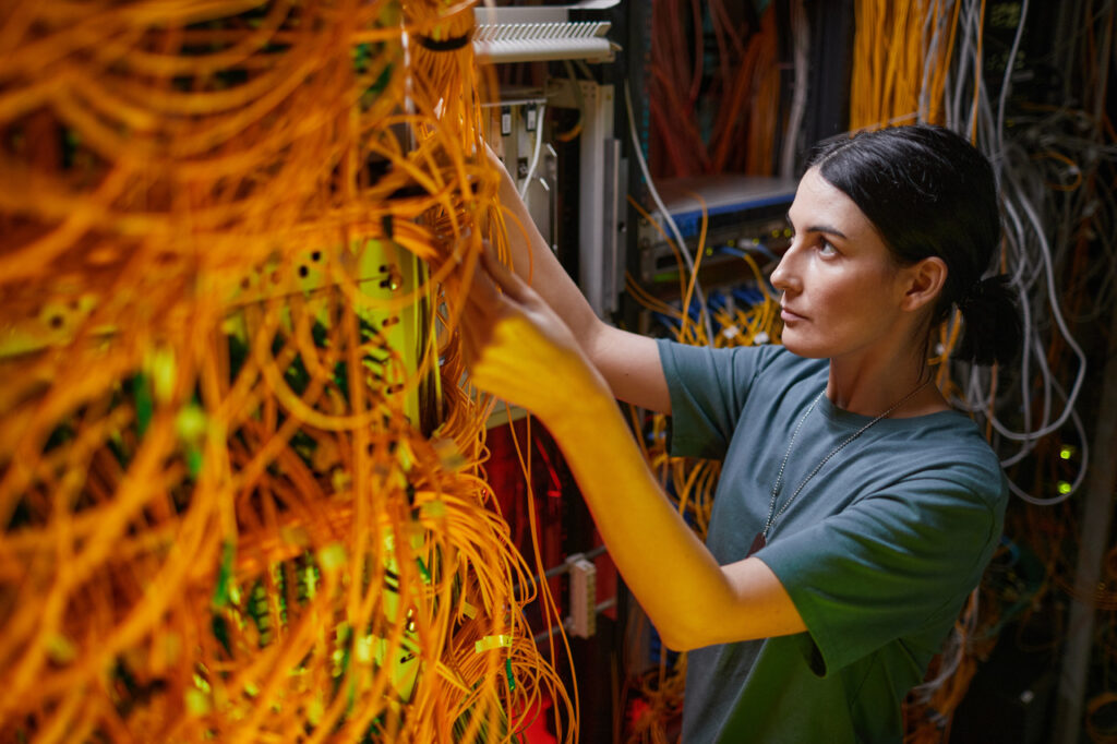 Woman works on network cabling installation in a small room