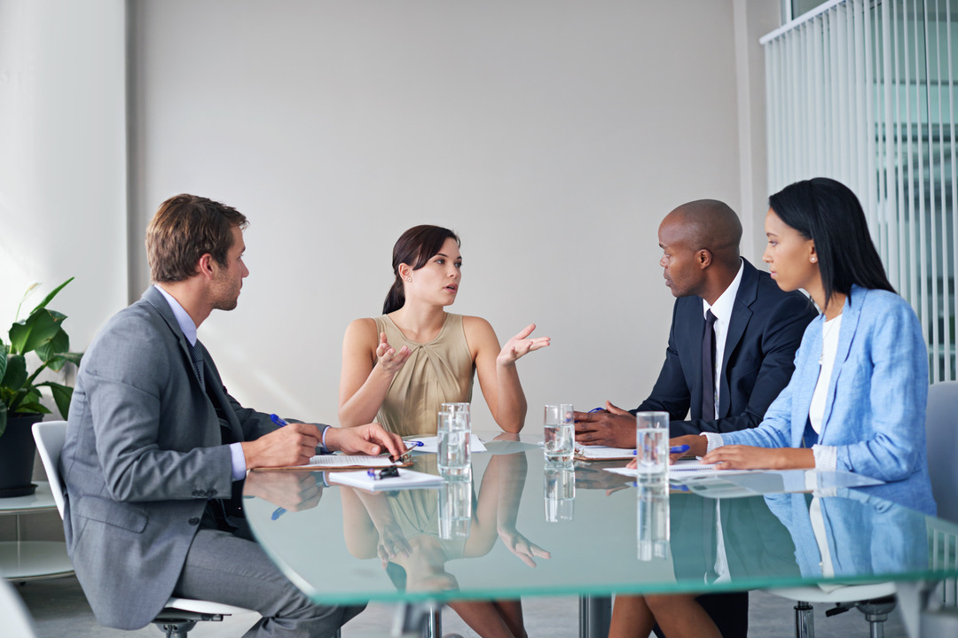 Young professionals sit around a table discussing their cyber insurance policy