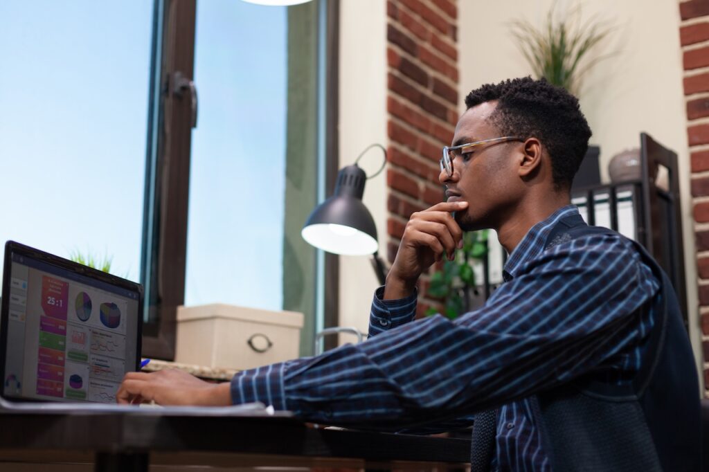 man working on computer in office using ai and cybersecurity tools