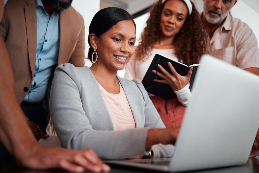 coworkers in office on computer looking over compliance requirements